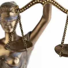 Złota statua Temidy z wagą sprawiedliwości, symbol prawa i porządku.