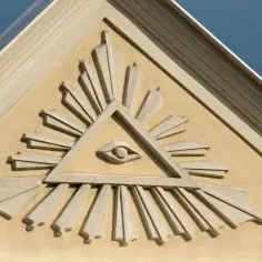 Kamienna płaskorzeźba przedstawia trójkąt z promieniującym okiem w środku – to symboliczne oko opatrzności, czuwające nad budynkiem.