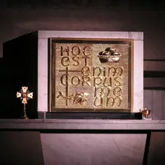 Złote tabernakulum z napisem "Hoc est enim corpus meum" i symbolem ryby. Obok krzyż relikwiarzowy.