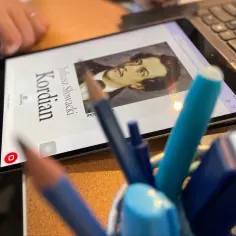 Na tablecie widnieje "Kordian" Juliusza Słowackiego, symbol poświęcenia i walki o wolność, niczym Winkelriedyzm w literaturze.