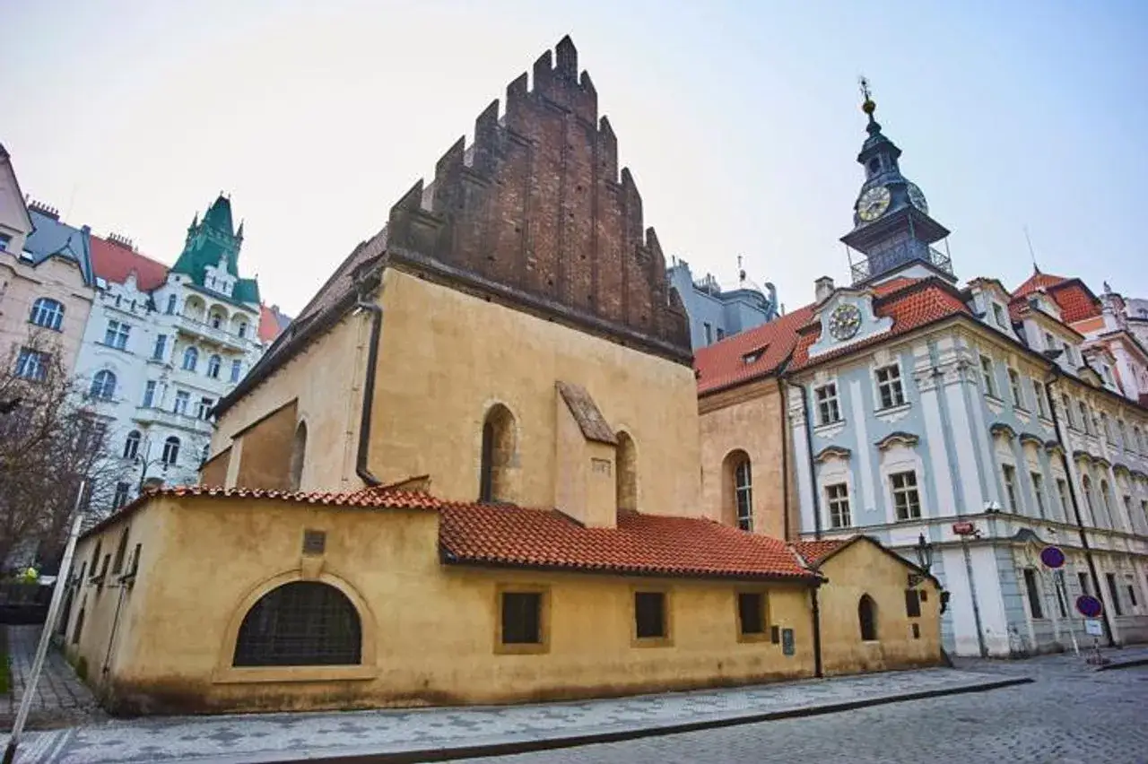 Stara Synagoga w Pradze, gdzie według legendy mieszkał golem. Obok kamienice i wieża zegarowa.