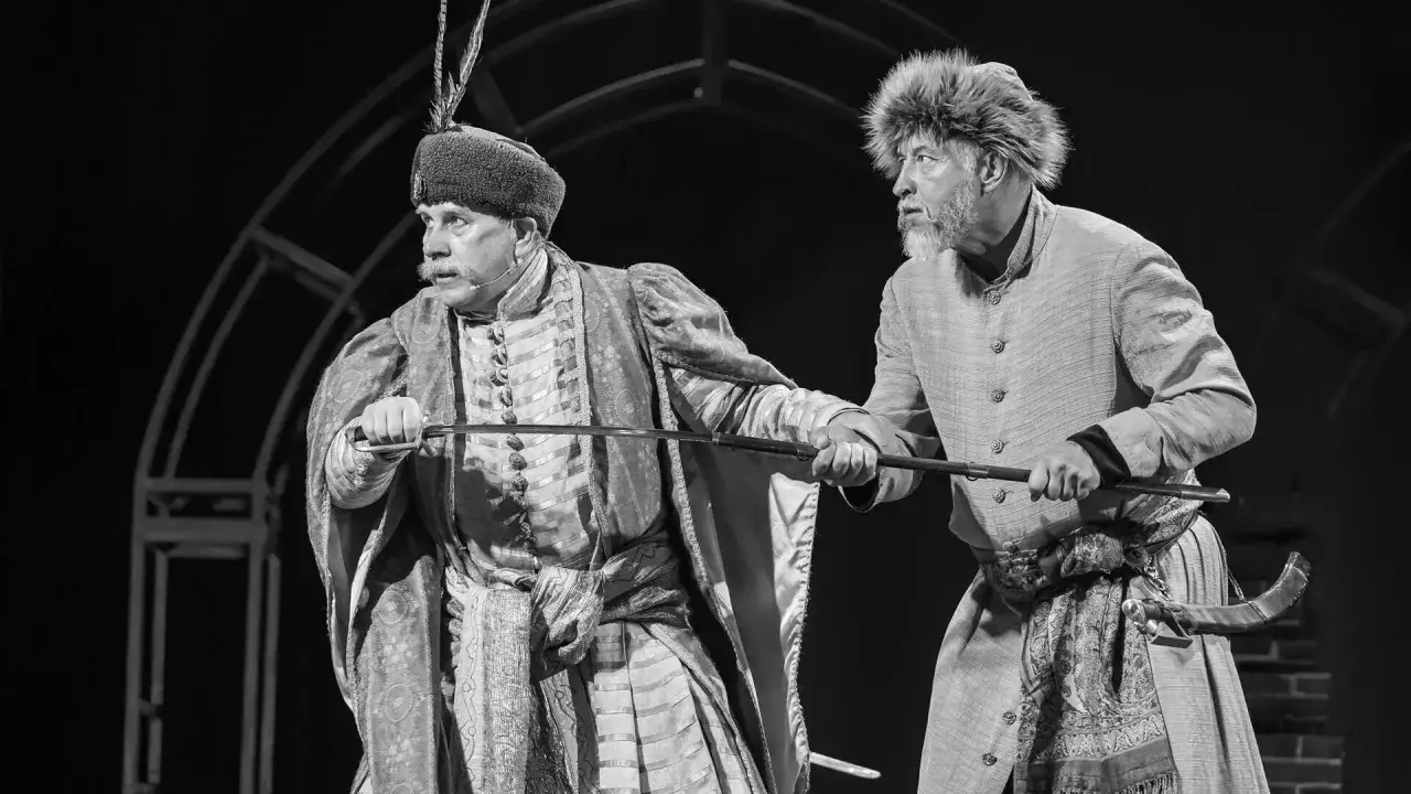 Dwóch mężczyzn w historycznych strojach, z mieczami w dłoniach, przygotowuje się do walki. Ich twarze wyrażają determinację, sugerując, że to zemsta bohaterów.